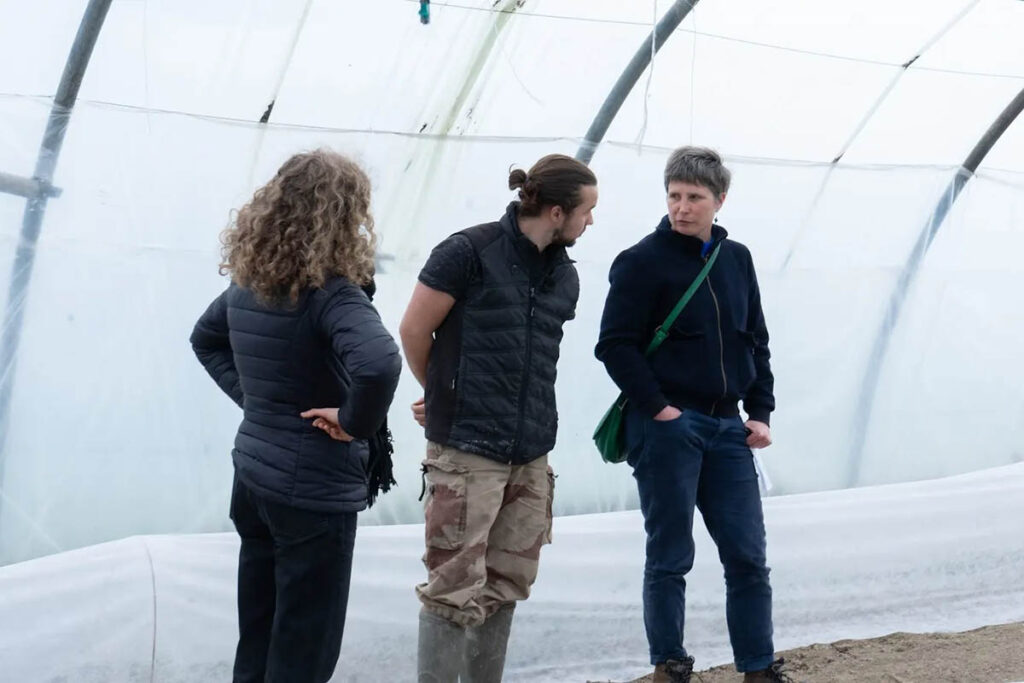 L’équipe de Local en Bocal échange avec un agriculteur sous une serre